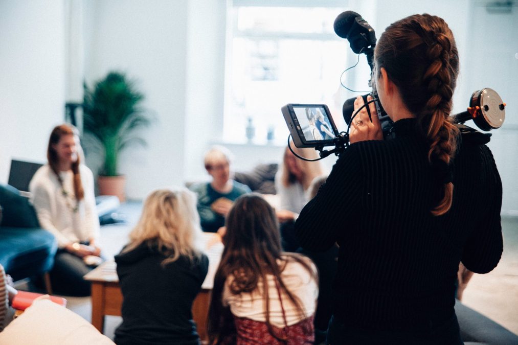 lady filming a group of financial employees to create a promotional video